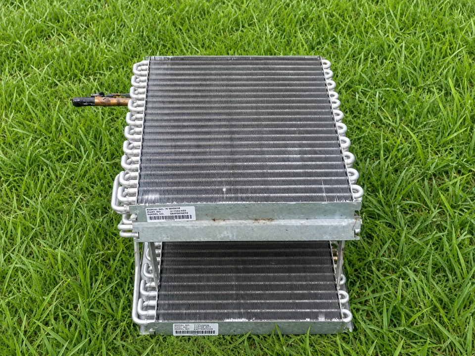 Wider view of the cleaned evaporator coil resting outside on grass